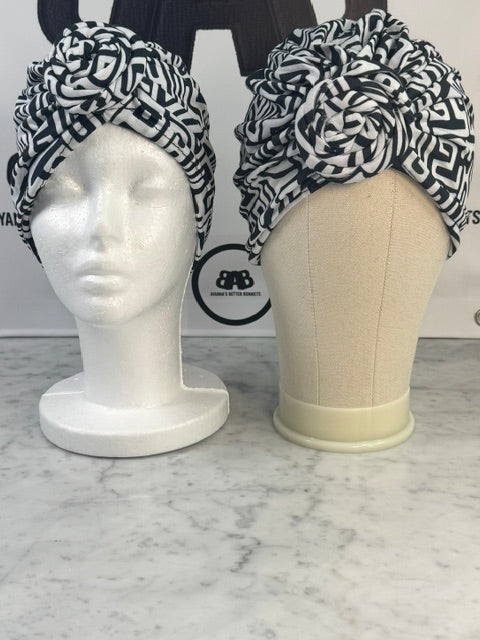 Both small and large mannequin heads wearing The Struggle Free Wrap, showing the headwrap fits a range of head sizes from approximately 21 to 25 inches in circumference
