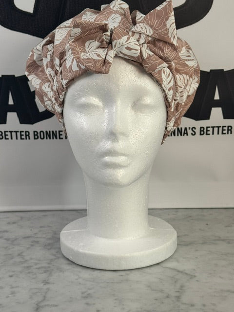 Floral shower cap on large canvas mannequin head showing fit on approximately 22-25 inch head circumference